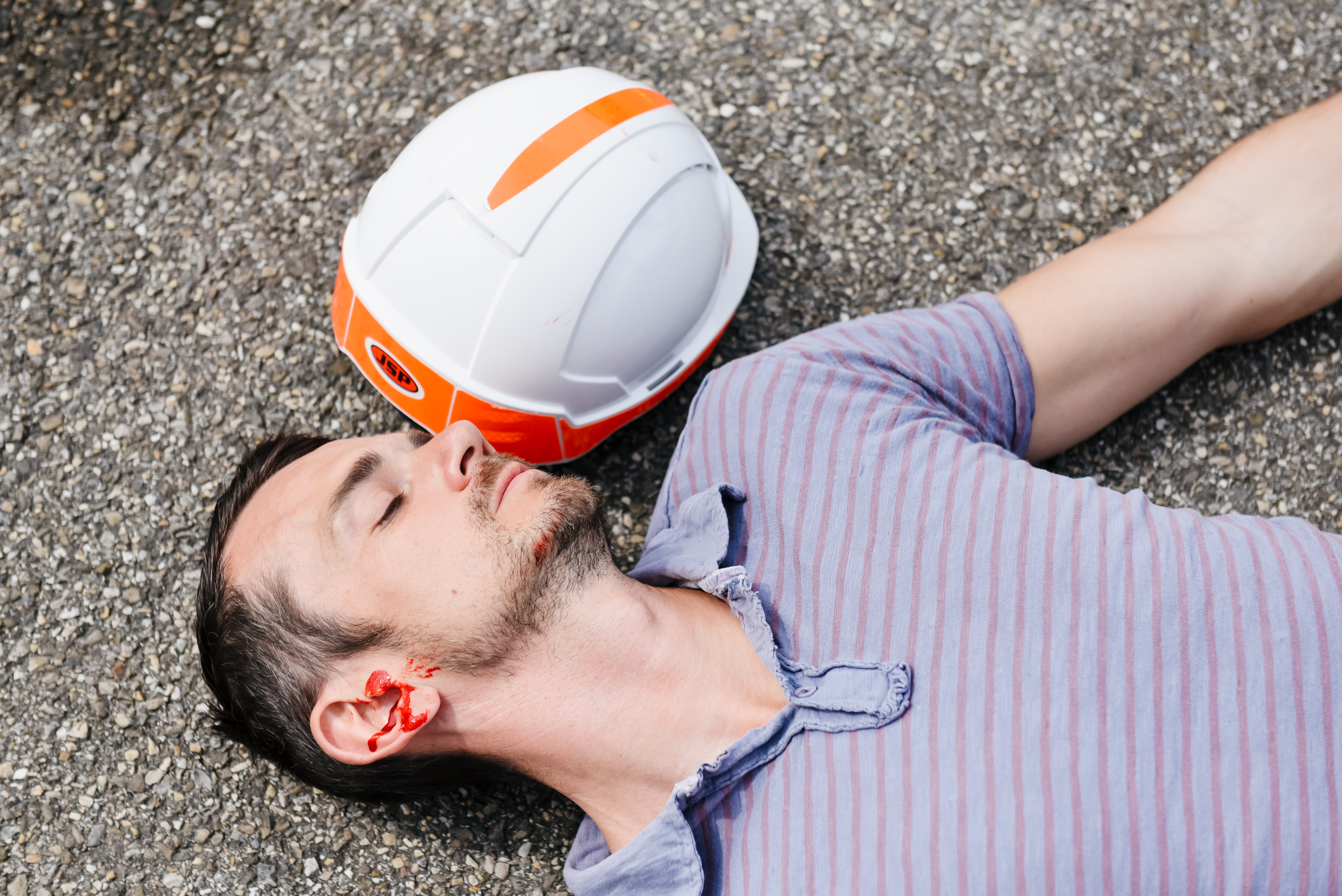 Homme inconscient au sol avec un saignement à l’oreille après un traumatisme crânien